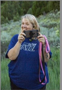 Stacey smiling with camera while hiking